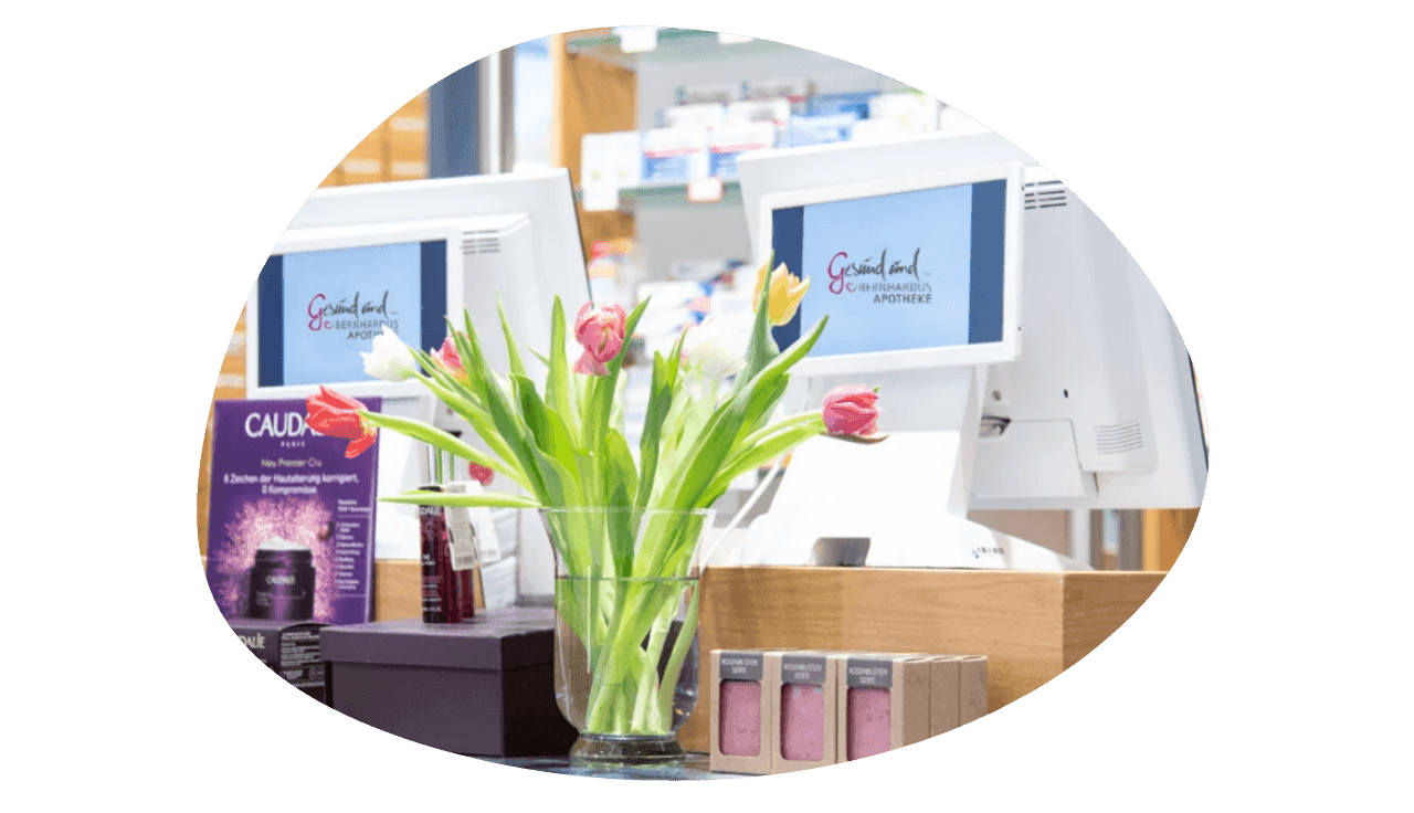 Moderne Apothekenkasse mit Tulpen im Vordergrund.