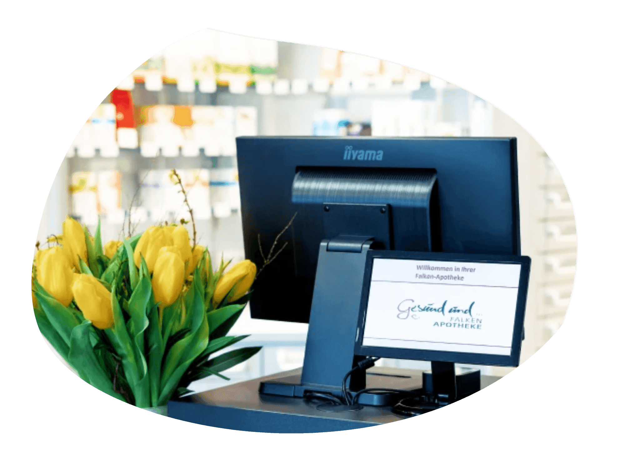 Moderne Apothekenkasse mit gelben Tulpen im Vordergrund.